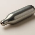 A metallic nang canister on a neutral background